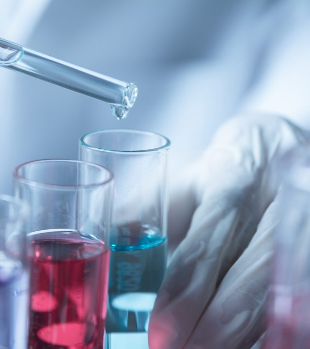 Researcher with glass laboratory chemical test tubes with liquid for analytical , medical, pharmaceutical and scientific research concept.